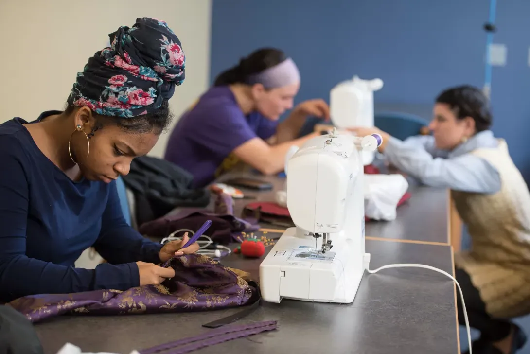 Fashion merchandising students at sewing machines